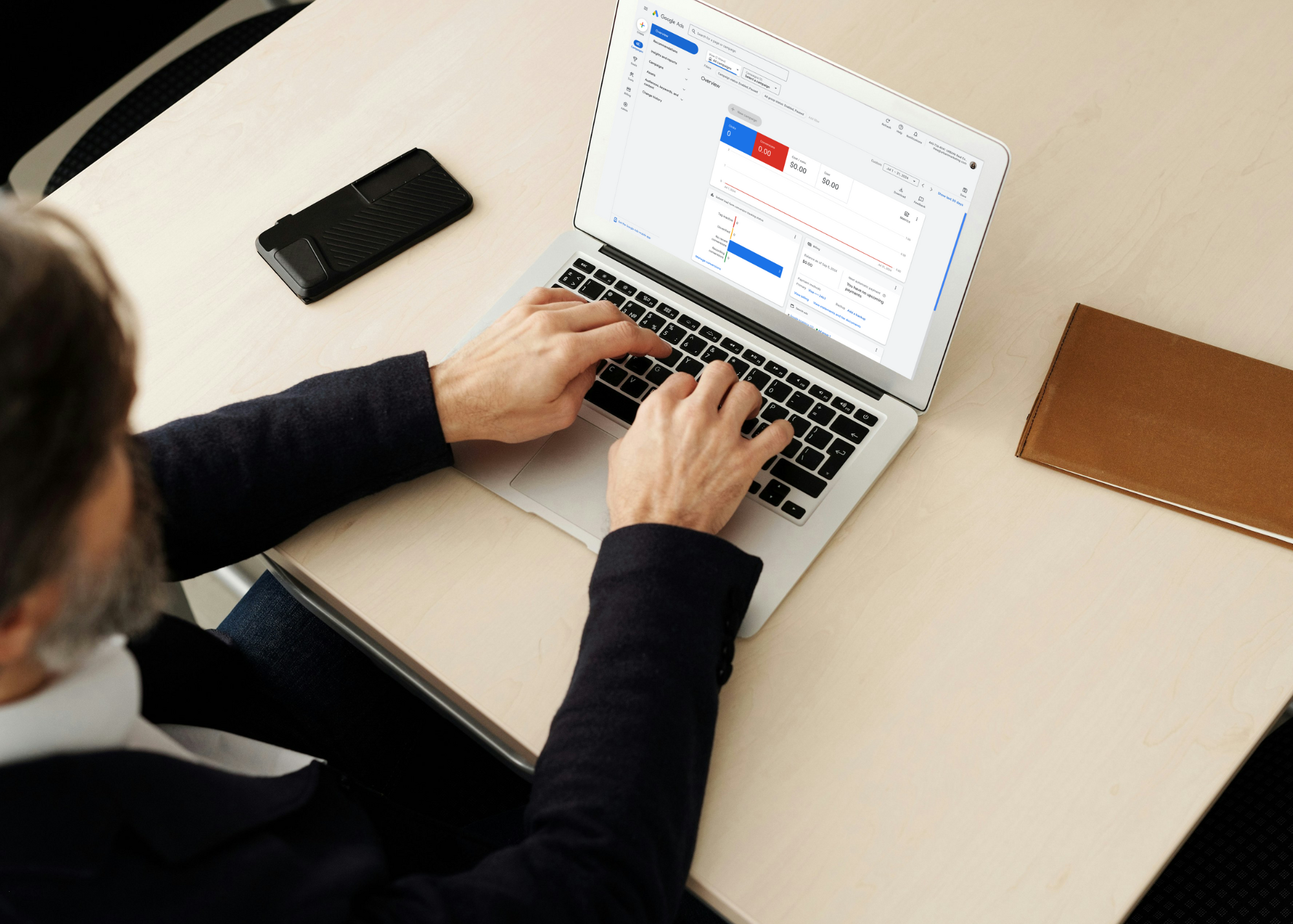 a man sites at a laptop with Google Ads pulled up on the screen.