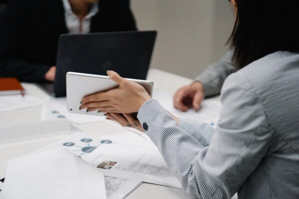 Marketing team reviewing printed charts and a tablet during a strategy meeting